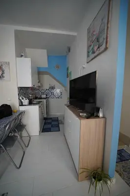a kitchen with a large flat screen tv on the wall at Casa di via Sole in Castellammare del Golfo