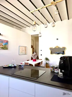 a kitchen with white cabinets and a black counter top at Da Lila a Ballarò in Palermo