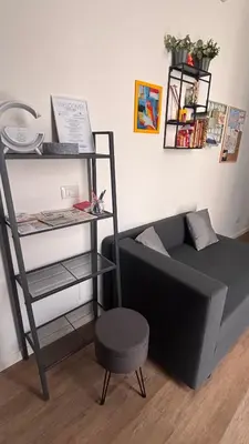 a room with a black couch and a shelf at caZA' Capo 40MQ nel centro di Palermo in Palermo