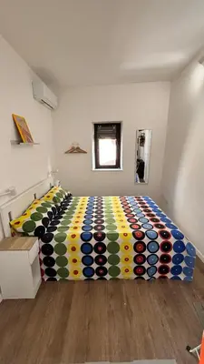 a bedroom with a bed with a colorful comforter at caZA' Capo 40MQ nel centro di Palermo in Palermo