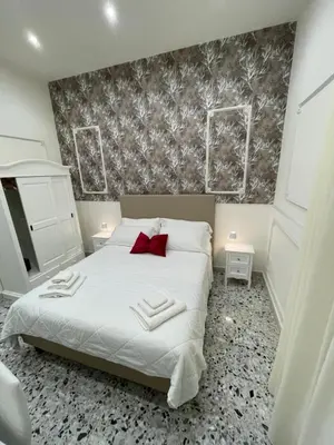 a bedroom with a white bed with a red pillow at Aragona House in Palermo