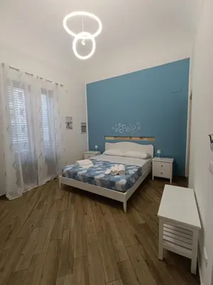a bedroom with a bed and a blue wall at Balarm Central Apartment in Palermo