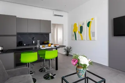 a kitchen with green chairs and a counter in a room at Cilea Apartments in Palermo