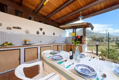 a kitchen with a table and chairs on a balcony at I Tre Golfi - Pianeti in San Vito lo Capo