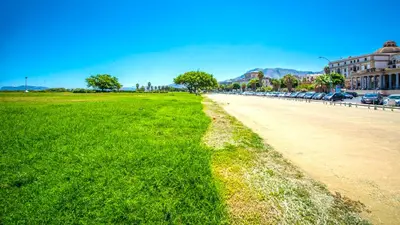 a field of grass next to a road with cars at Kalsa miniLoft by Wonderful Italy in Palermo