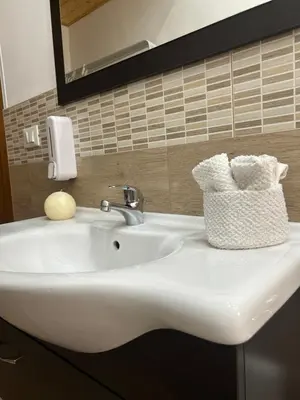 a white sink in a bathroom with a mirror and towels at Home Love in Palermo