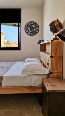 a bedroom with a bed and a clock on the wall at The blue and red rooms in Bagheria