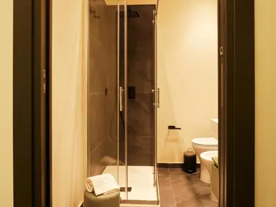 a bathroom with a shower and a toilet at HUB Rooms in Carini