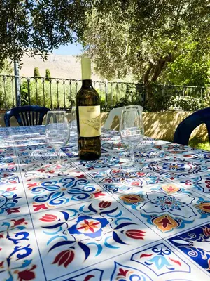 a bottle of wine sitting on a table with wine glasses at Sole di Sicilia in Castelluzzo
