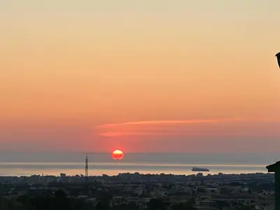 a sunset over the ocean and a city at Casa Maria Grazia Villa indipendente con vista mozzafiato a Monreale in Monreale