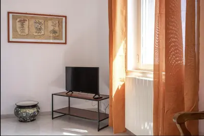 a tv sitting on a table next to a window at Casa Maria Grazia Villa indipendente con vista mozzafiato a Monreale in Monreale