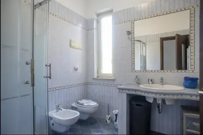 a bathroom with a sink and a toilet and a mirror at Casa Maria Grazia Villa indipendente con vista mozzafiato a Monreale in Monreale