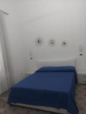 a bedroom with a blue bed in a white room at Guest House Militello in Palermo