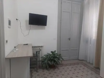 a room with a table and a tv on the wall at Guest House Militello in Palermo