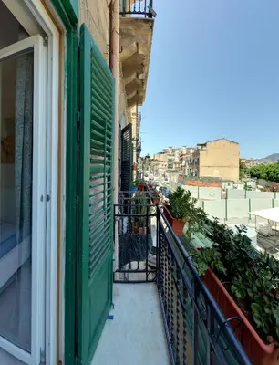 a balcony with green shutters on a building at Isola dei tesori - affittacamere palermo in Palermo