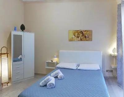 a bedroom with a blue bed with towels on it at Isola dei tesori - affittacamere palermo in Palermo