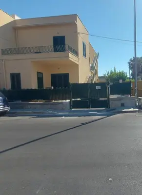 a house with a fence in front of a street at Mondello House in Palermo