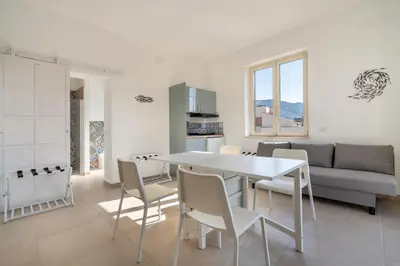 a kitchen and living room with a table and chairs at Mondello House in Palermo