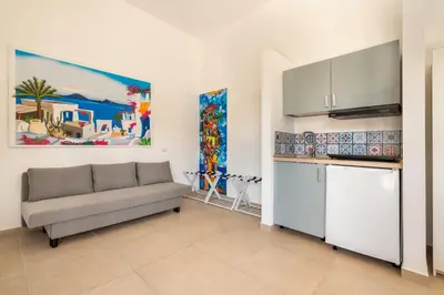 a living room with a couch and a kitchen at Mondello House in Palermo