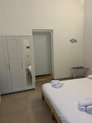 a bedroom with two beds and a mirror at Mondello House in Palermo