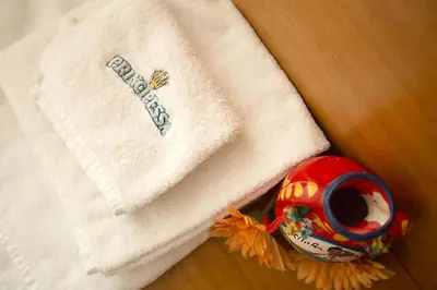 a towel and a cup next to a napkin at Albergo La Principessa in Alcamo