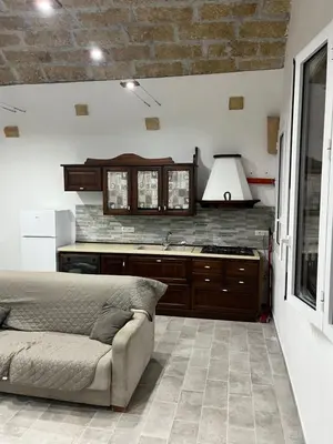 a living room with a couch and a kitchen at Casa vacanze Giada in Terrasini