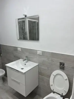 a bathroom with a toilet and a sink and a mirror at Casa vacanze Giada in Terrasini