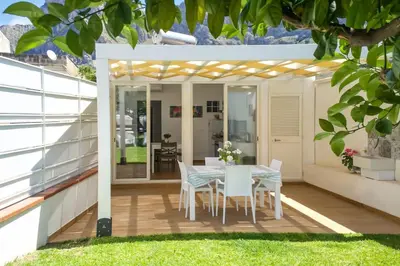 a patio with a table and chairs on a deck at Casa vacanze Casuzza Sferracavallo Palermo in Palermo