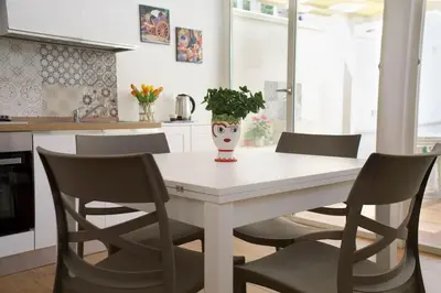 a kitchen with a table with chairs and a vase on it at Casa vacanze Casuzza Sferracavallo Palermo in Palermo