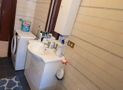 a bathroom with a sink and a washing machine at La Casetta di Ale in Isola delle Femmine