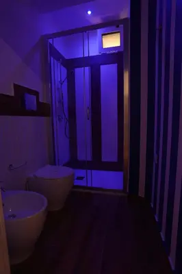 a dark bathroom with a toilet and a sink at De Spuches House in Caccamo