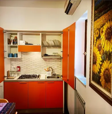 a kitchen with red cabinets and a painting of sunflowers at Casa del Blu in Palermo