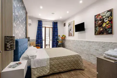 a hotel room with a bed and a tv at Luxury House Ballarò in Palermo