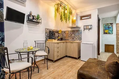a kitchen and a living room with a table and chairs at Luxury House Ballarò in Palermo