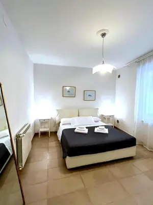 a bedroom with a large bed with two towels on it at Casetta Bontà in Palermo
