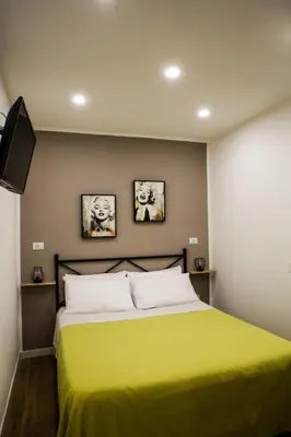 a bedroom with a yellow bed with two pictures on the wall at Scillò House in Palermo