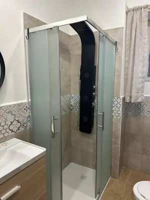 a shower with a glass door in a bathroom at Scillò House in Palermo
