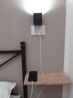 a room with a bed with a light on a table at Scillò House in Palermo