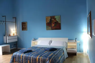 a blue bedroom with a bed with a blue wall at FALSTAFF Rooms & Suites in Palermo