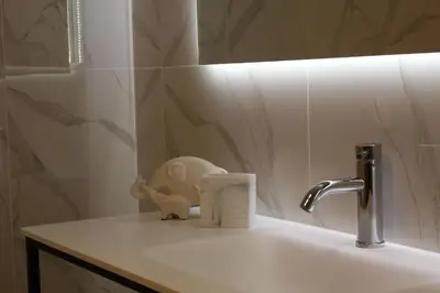a bathroom sink with a faucet and a mirror at FALSTAFF Rooms & Suites in Palermo