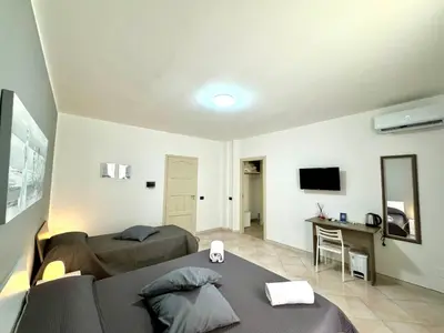 a living room with two beds and a desk at B&B Blue in Terrasini