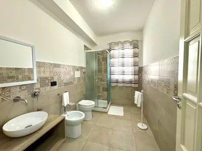 a bathroom with two toilets and a sink and a shower at B&B Blue in Terrasini