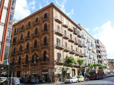 a tall building with cars parked in front of it at B&B Salinas in Palermo