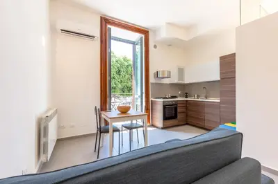 a kitchen and living room with a couch and a table at Loft Piazza Marina By DomuSicily in Palermo