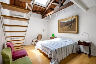 a bedroom with a bed and a spiral staircase at Elvi Penthouse by DomuSicily in Palermo
