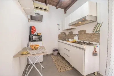 a small kitchen with white cabinets and a table at La Casa di Sciù Sciù in Palermo