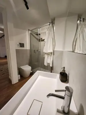 a white bathroom with a sink and a shower at La Casa Di Mitì in Palermo