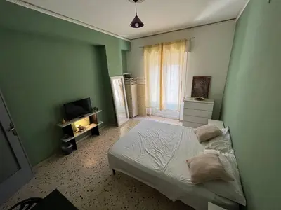 a green bedroom with a bed and a television at Casina Della Strega in Palermo