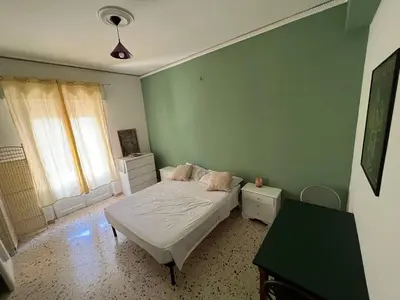a bedroom with a bed and a green wall at Casina Della Strega in Palermo