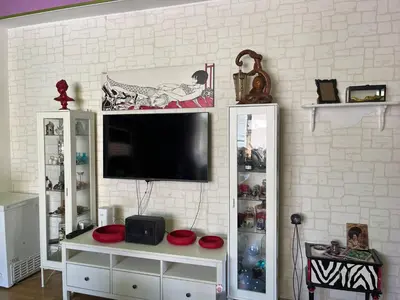 a living room with a tv on a wall at Casina Della Strega in Palermo